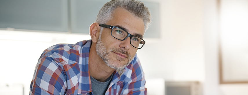 Middle-aged man looking tired and mentally drained in a kitchen due to fatigue and low energy.