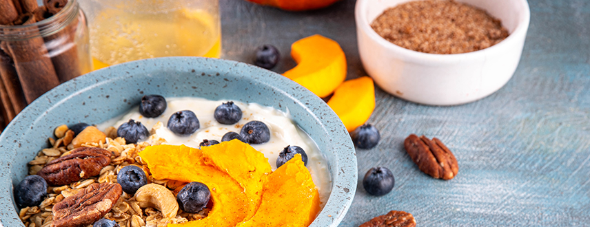 Healthy fall breakfast bowl with yogurt, blueberries, pecans and pumpkin